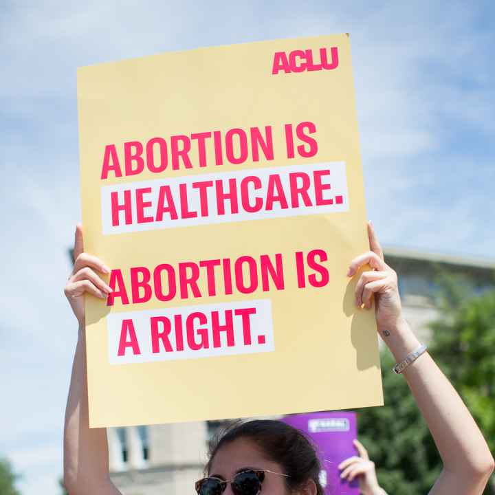 Protester holding sign that reads "Abortion is healthcare. Abortion is a right."