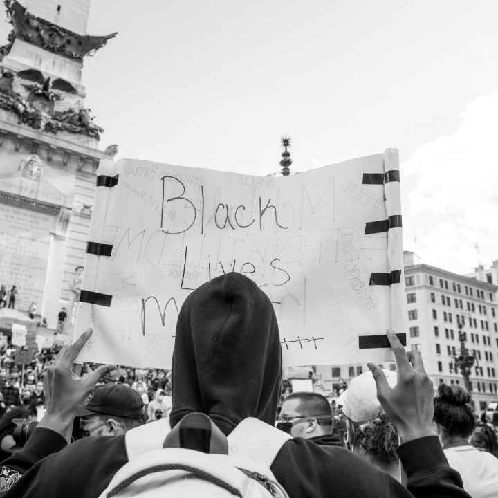 Protester holding black lives matter sign on monument circle